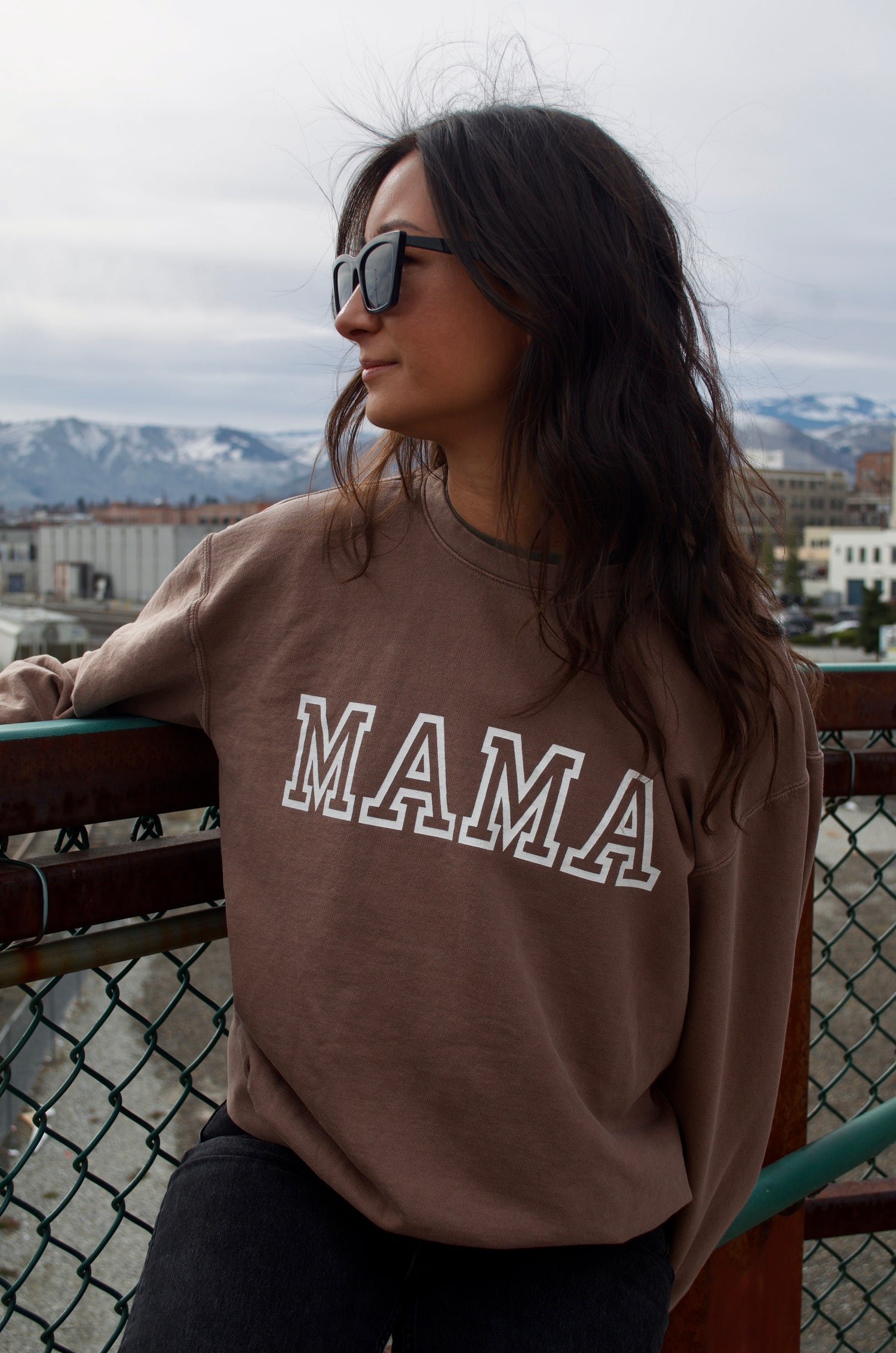 Girl in mocha graphic sweatshirt that has the word mama printed on it